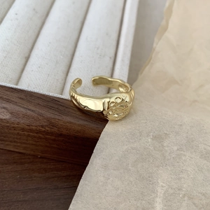 Macro shot of irregular hammer texture and adjustable open band on gold silver ring