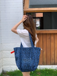 Detail der blauen Canvas-Tasche mit Leopardenmuster, Beach-Schriftzug und Webband