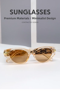 Close-up of cat-eye sunglasses with gold metal studs and geometric cut-out arms