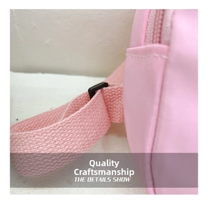 Macro detail of pink nylon shoulder strap with adjustable black plastic buckle and stitching