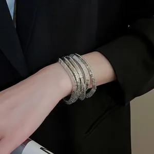 Chic multi-layered silver metal wrap bracelet with ribbed texture on a model wearing black