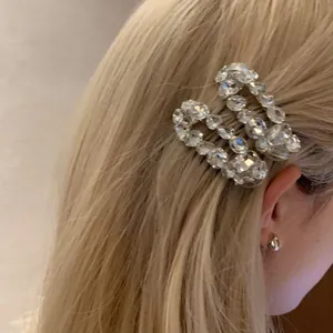 Close-up of a luxury wave-shaped hair clip with sparkling crystals on blonde hair