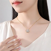 Close-up of elegant gold necklace with sparkling snowflake pendant on a woman neck