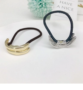 Detail view of gold and silver U-shaped metal ponytail holders on white background