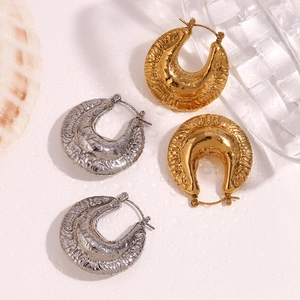 Detail of irregular texture on gold and silver chunky hoop earrings with water drops