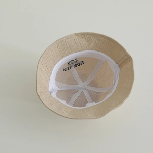 Detailed interior of beige kids bucket hat with Keep Good embroidery and windproof strap
