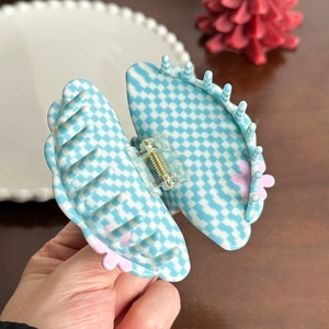 Blue and white checkered acetate hair claw clip with pink floral accents and golden spring