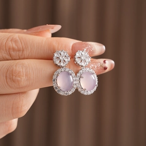 Gros plan de boucles d'oreilles vintage en calcédoine rose avec détails en zircon