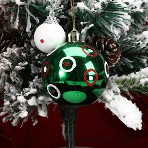 Close-up of green festive ball with concentric circles on snowy Christmas tree branches