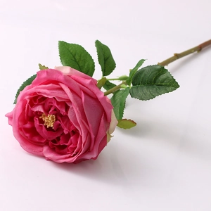 Close-up of artificial Austin rose with realistic magenta petals and green leaves