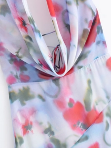 Macro detail of breathable chiffon fabric with vibrant floral print on halter midi dress