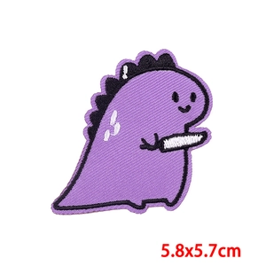 Detalle del parche bordado de dinosaurio morado con medida de talla 5,8x5,7 cm
