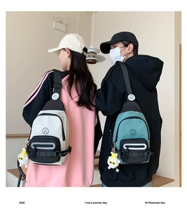 Détails des sacs de poitrine en nylon beige et vert avec bandes réfléchissantes et breloques