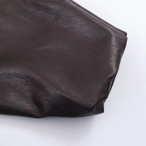 Macro close-up showing the soft lychee grain texture of the faux leather jacket fabric