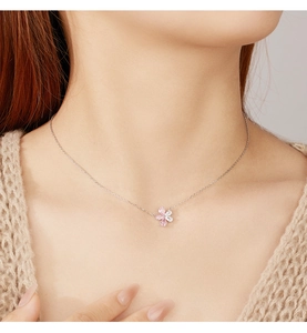 Detail of five-petal flower necklace with pink and white crystals on silver chain