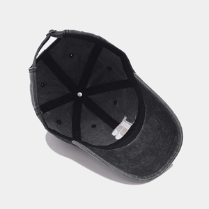 Detail view of washed cotton baseball cap showing internal stitching and adjustable metal buckle