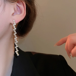 Detail of elegant gold-toned irregular fringe earrings set with sparkling zircon stones