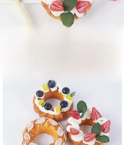 Macro di una ciambella artificiale alla fragola con panna e guarnizioni realistiche