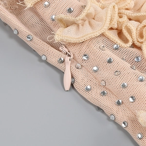Detail of warm apricot mesh dress featuring delicate lace, silver rhinestones, and zipper