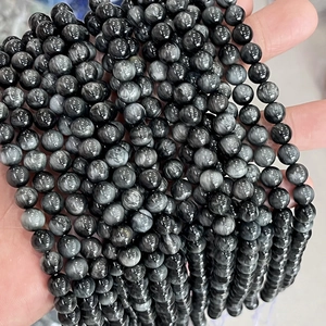 Detailed close-up of natural hawk eye stone round beads with silk-like cat eye effect