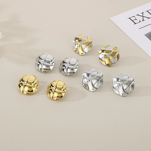Close-up of geometric woven texture earrings in gold and silver metal finishes