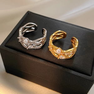 Makro-Detail von 18k vergoldeten Perlenringen mit Zirkonia-Inlays auf schwarzer Box