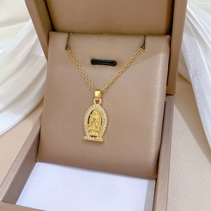 Close-up of golden Lady of Guadalupe oval pendant with crystals on velvet