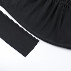 Detail of sheer black mesh sleeves and ruched fabric texture on an off-shoulder dress