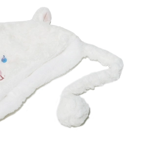 Detailed macro view of white plush material with cute blue sequin cat eyes and embroidery