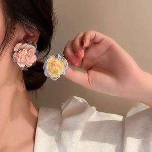 Asymmetric floral stud earrings with contrast fabric petals in pink and yellow hues