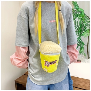 Detail of cute plush popcorn shaped crossbody bag worn by a model with yellow strap