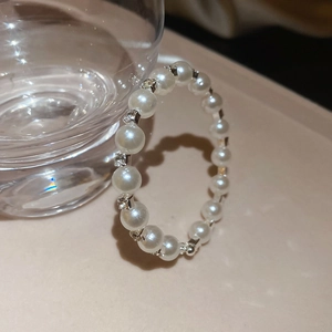 Detailed macro view of delicate white pearls and sparkling rhinestones on the beaded bracelet