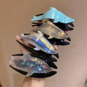 Detail of colorful dolphin hair claws with sparkling gradient and star rhinestone eyes