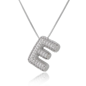 Macro shot of silver letter E bubble pendant with micro-pave cubic zirconia on box chain