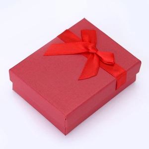 Elegant red gift box with cross-pattern texture and a satin ribbon bow at a 45-degree angle