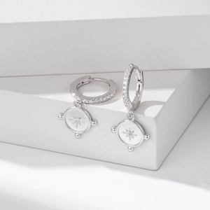 Detailed macro view of S925 silver star earrings on a minimalist white display