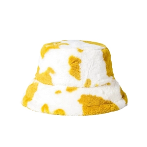 Winter plush bucket hat with yellow and white cow print texture for outdoor warmth