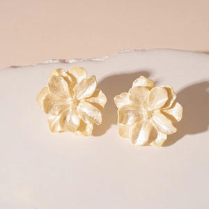 Boucles d'oreilles fleurs 3D crème nacrées élégantes sur socle en pierre minimaliste