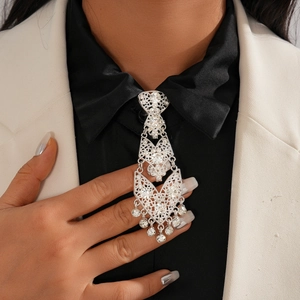 Close-up of a silver geometric hollow tassel necklace with sparkling rhinestones on a blazer