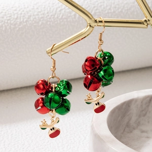 Detailed shot of Christmas earrings with red and green bells and gold reindeer charms
