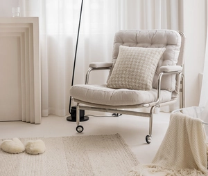 Detail view of beige fabric lounge chair with metal frame and matching patterned pillow
