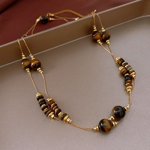 Detail of vintage double-layer necklace with brown tiger eye beads and gold spacers