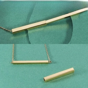 Macro view showing the detachable screw top of this golden bar pendant for aromatherapy