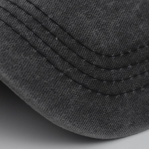 Detail view of washed grey cotton baseball cap brim with precise reinforced stitching