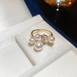 Close-up of golden French retro C-shaped earrings with pearls and zircon in a jewelry box
