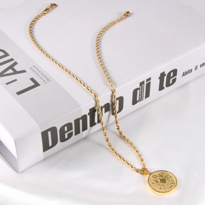 Detailed close-up of 18K gold plated Cancer zodiac coin pendant on twisted chain