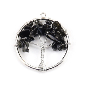 Detailed view of silver tree of life pendant with natural black crystal stones