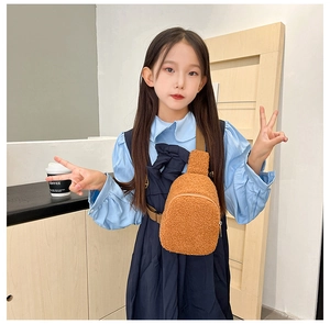 Detail of child wearing a brown plush crossbody bag with soft faux fur and adjustable strap