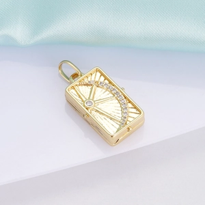 Macro detail of 18K gold locket pendant with sunburst design and inlaid gemstones