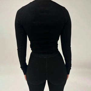 Détail de la texture en maille côtelée noire au dos d'un ensemble de yoga ajusté